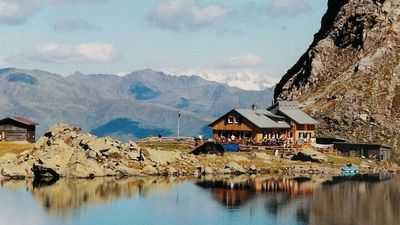 Ein Anblick, der jeden Aufstieg belohnt: Der tiefblaue Obstanser See im Osttiroler Teil der Karnischen Alpen mit der gleichnamigen Hütte