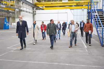 TUP-Geschäftsführer Fritz Frömming, Oberbürgermeister Thomas Kufen und TUP-Werkstattdirektor Ralf Gehrke (vorne v.l.) sowie Mitglieder des TUP-Aufsichtsrates besichtigen die neuen Werkstatthallen der Theater und Philharmonie Essen