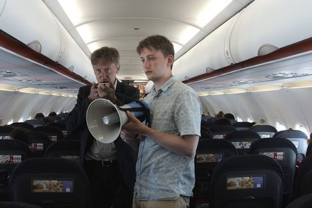 Mux (Jan Henrik Stahlberg) und Karsten (TilmanVellguth) versuchen Flugzeugpassagiere vom Muxismus zu überzeugen
