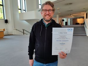 Chorleiter Patrick Jaskolka mit der Siegerurkunde des Wettbewerbs Chorleiter Patrick Jaskolka mit der Siegerurkunde des Wettbewerbs