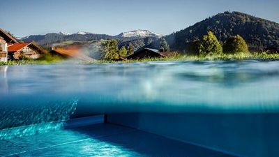 Unten grüne Wälder und Wiesen, oben noch schneebedeckte Gipfel – die Nebensaison zeigt sich bei Haubers Naturresort im Allgäu von ihrer ruhigsten und schönsten Seite