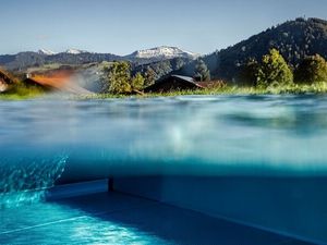 Unten grüne Wälder und Wiesen, oben noch schneebedeckte Gipfel – die Nebensaison zeigt sich bei Haubers Naturresort im Allgäu von ihrer ruhigsten und schönsten Seite