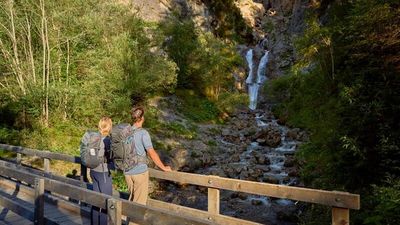 Auf dem Lechweg-Teilabschnitt in Steeg/Tiroler Lechtal kommen Wanderer an der Natur-Kneippanlage Griesbacherwasserfall vorbei