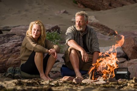 Raynor (Gillian Anderson) und Moth Winn (Jason Isaacs) wärmen sich am Feuer