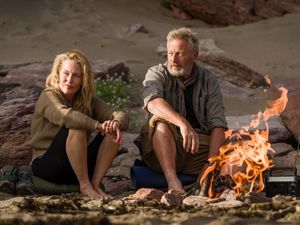 Raynor (Gillian Anderson) und Moth Winn (Jason Isaacs) wärmen sich am Feuer Raynor (Gillian Anderson) und Moth Winn (Jason Isaacs) wärmen sich am Feuer