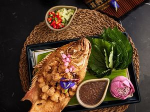 Knuspriger roter Tilapia mit Betelblättern Knuspriger roter Tilapia mit Betelblättern