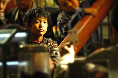 Das kleine Mädchen (Mucheng Guo) beobachtet einen Kartentrick