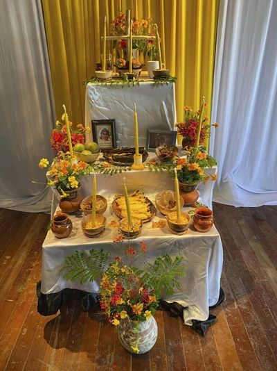 Altar mit Kerzen, Essen und Bildern