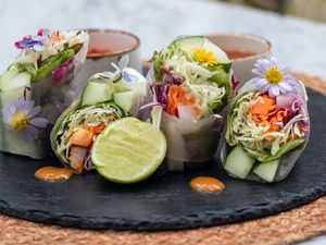 Spargel, Avocado, Salat, Karotten und Minze füllen die veganen Sommerrollen des Centara Reserve Samui, serviert mit einer süß-feurigen Erdnuss-Chili-Soße