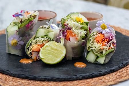 Spargel, Avocado, Salat, Karotten und Minze füllen die veganen Sommerrollen des Centara Reserve Samui, serviert mit einer süß-feurigen Erdnuss-Chili-Soße