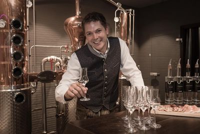 Beim Besuch des Alpin Life Resort Lürzerhof in Untertauern/Österreich schauen Gäste Eigentümer Harald Habersatter in der hauseigenen Brennerei bei der Herstellung von Edelbränden und Likören über die Schulter