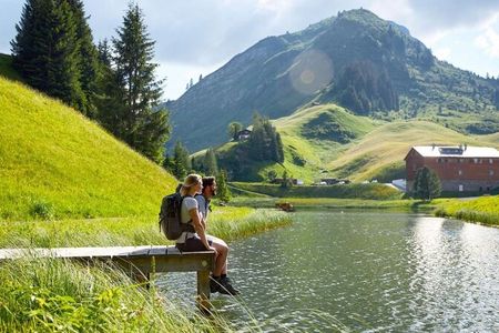 Auf dem Lechweg von Lech nach Warth in Vorarlberg kommen Wanderer am kleinen, idyllischen Seebachsee vorbei
