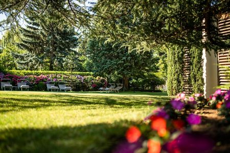 Gäste entspannen in der liebevoll gepflegten Gartenanlage des Hotel Mignon Meran Park & Spa. Das mediterrane Klima in Südtirol sorgt für ideales Outdoor-Wetter bis in den Spätherbst