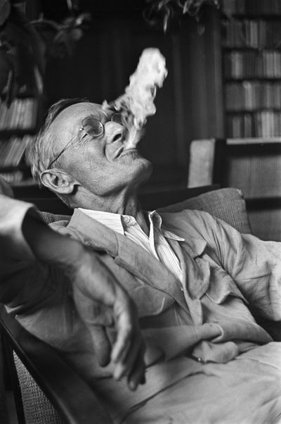 Martin Hesse: Der Schriftsteller, Dichter und Maler Hermann Hesse rauchend in der Bibliothek der Casa Rossa in Montagnola, aufgenommen im Jahr 1935