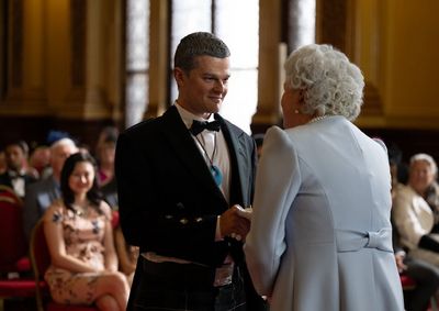 John (Robert Aramayo) bei der Ordensverleihung durch die Queen