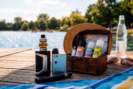 Entspannung am Wasser: Damit der Ausflug an den Badesee ein Genuss bleibt, sollten Vapes und E-Liquids stets griffbereit, aber gut geschützt vor direkter Hitze aufbewahrt werden