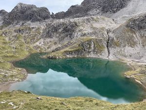 Der Roßkarsee schimmert tiefgruen, umringt wird das Berggewaesser von schroffen Felsformationen der Lechtaler Alpen Der Roßkarsee schimmert tiefgruen, umringt wird das Berggewaesser von schroffen Felsformationen der Lechtaler Alpen