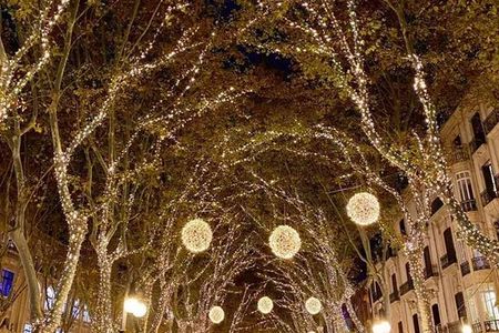 In der mallorquinischen Hauptstadt Palma flanieren Gäste des Hotel Cort und des Grupotel Playa de Palma Suites & Spa unter einem strahlenden Lichtermeer