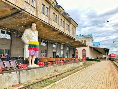 Eine lebhafte, industrielle und farbenfrohe Bar namens PERONAS hat sich direkt an den Gleisen in der Nähe des alten Bahnhofsgebäudes in Vilnius niedergelassen