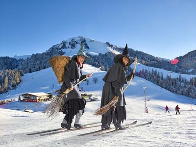 In der Skiwelt Wilder Kaiser  Brixental freuen sich große Urlauber ueber die Berge, die Juengeren begegnen ab und an sogar echten Hexen auf der Piste