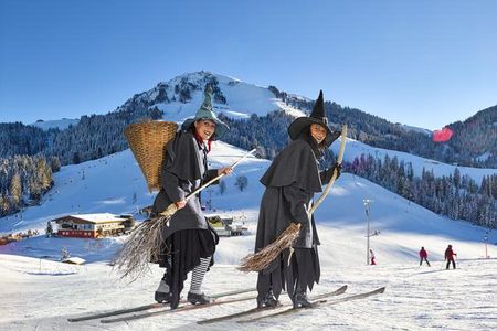 In der Skiwelt Wilder Kaiser  Brixental freuen sich große Urlauber ueber die Berge, die Juengeren begegnen ab und an sogar echten Hexen auf der Piste