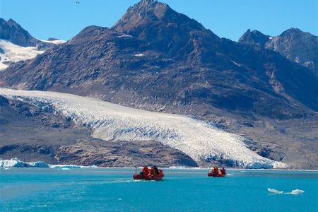 Mit Motorbooten brechen Hauser-Gaeste zum kalbenden Knud-Rasmussen-Gletscher auf, benannt nach Groenlands beruehmten Polarforscher