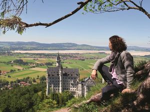 Schauspieler Jakob Graf, einer der Protagonisten der Anderszeit-Stories auf der Füssen-Website, mit Schloss Neuschwanstein/Allgäu im Hintergrund