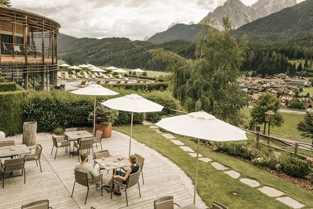 Von der Terrasse des Naturhotel Leitlhof in Südtirol haben Feinschmecker beim Aperitif freie Sicht auf die Sextner Dolomiten