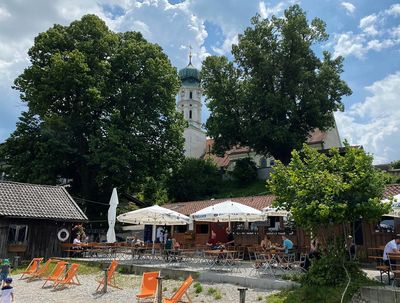 Direkt am Seeufer und idyllisch unterhalb der Seeshaupter Pfarrkirche St. Michael gelegen, lädt der kleine Biergarten beim Strandbad Lidl zum Baden und Einkehren ein