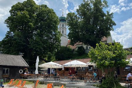 Direkt am Seeufer und idyllisch unterhalb der Seeshaupter Pfarrkirche St. Michael gelegen, lädt der kleine Biergarten beim Strandbad Lidl zum Baden und Einkehren ein