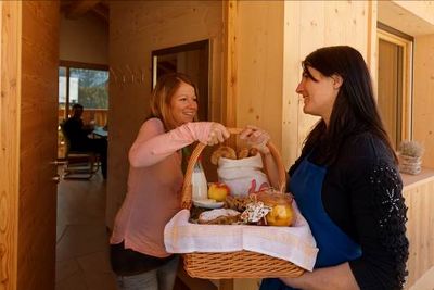 Den reichlich mit hofeigenen Suedtiroler Produkten befuellten Fruehstückskorb bringt die Roter Hahn Baeuerin direkt vor die Ferienwohnung