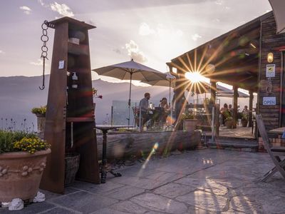 Saluti dal Ticino – im Außenbereich des auf 1.400 Metern gelegenen Ristoro Sass Malt im Südschweizer Malvaglia greifen Gäste beim Sonnenuntergang nach dem Glas und manchmal sogar zu den Sternen