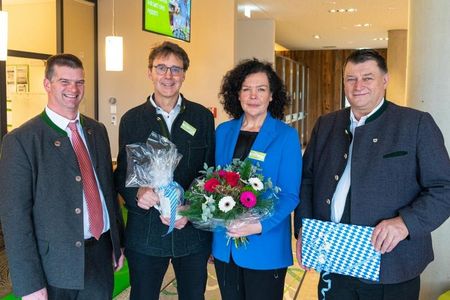 Christian Hornsteiner, Bürgermeister Farchant (links) und Anton Speer, Landrat Landkreis Garmisch-Partenkirchen (rechts), beglückwünschen Jürnjakob Reisigl und Katja Leveringhaus zur Eröffnung