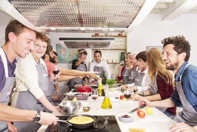 In entspanntem Ambiente bereiten Gaeste des Hotel Tres in Palma Mallorca in den Koch Workshops von Lonja 18 spanische Koestlichkeiten zu