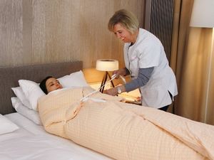 Packerin Eleonore Perschl wickelt Schrothkur-Gaeste des Fuenf-Sterne-Hotels Allgaeu Sonne in Oberstaufen zur Mobilisierung der Abwehrkraefte in feuchtkalte Handtuecher