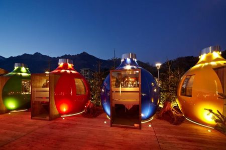 Beim Dinner in einer der Kugln auf dem Platz vor der Therme Meran speisen Gäste entspannt inmitten des Weihnachtsmarkt-Trubels der Südtiroler Kurstadt