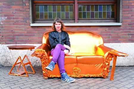 Kuenstlerin Anna Witt vor dem Hauptquartier auf einem der im Wokshop entstandenen Design-Moebel - Projekt Breaking New