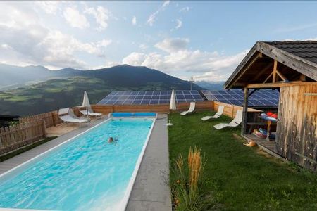 Pool mit Bergblick auf einem der hoch gelegenen Suedtiroler Bauernhoefe der Marke Roter Hahn