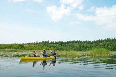 Beim Anpaddeln erkunden aktive Urlauber die abwechslungsreiche und unberuehrte Natur der Mecklenburgischen Seenplatte vom Kanu aus