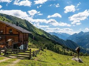 Eine Almhütte, ein Marterl, unberührte Natur und Berge, soweit das Auge reicht