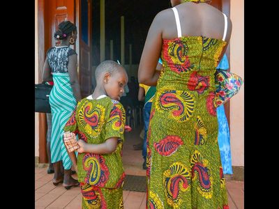 Mutter und Sohn warten vor einer Kirche in Entebbe am Viktoriasee