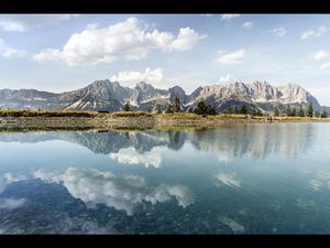 Das imposante Massiv des Wilden Kaiser in Oesterreich spiegelt sich im Astbergsee, oberhalb von Going gelegen Das imposante Massiv des Wilden Kaiser in Oesterreich spiegelt sich im Astbergsee, oberhalb von Going gelegen