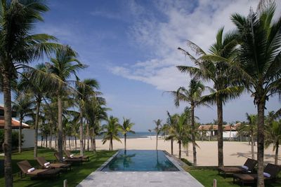 The Nam Hai Pool mit Palmen